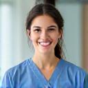 A healthcare worker in scrubs smiling kindly