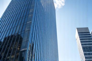 Sleek modern office building in a bustling city skyline, representing commercial properties.